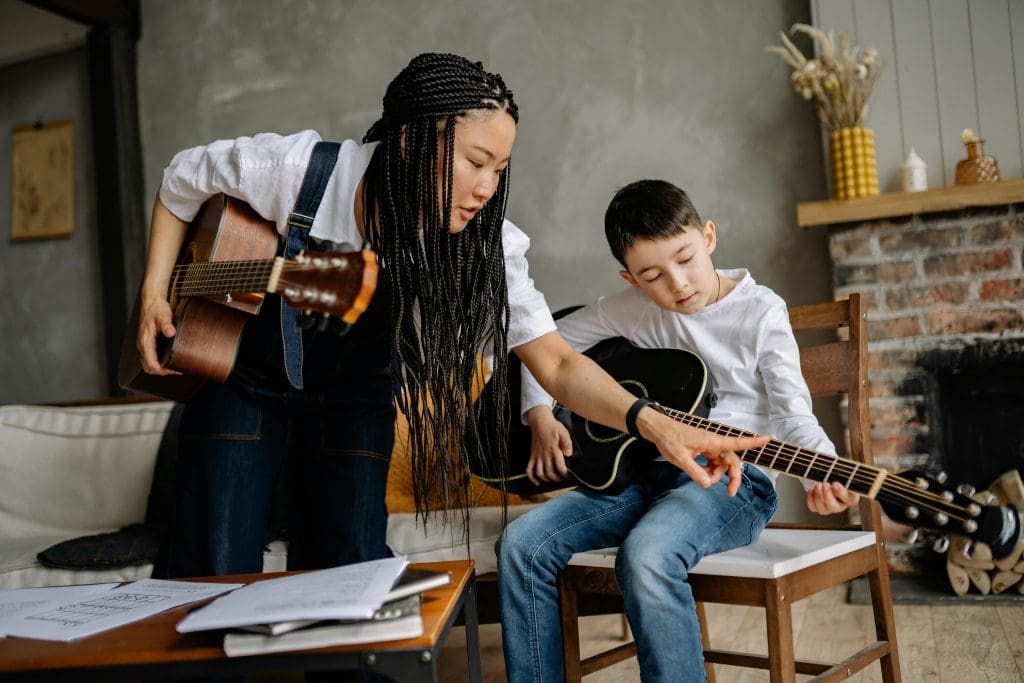 Photo of a music tutor in Nashville working with a student to learn autistic guitar